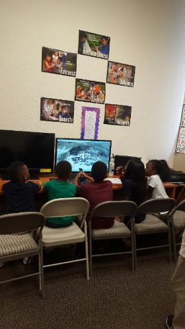 Students at the computer station beneath posters on respect, honesty, fairness and other character values
